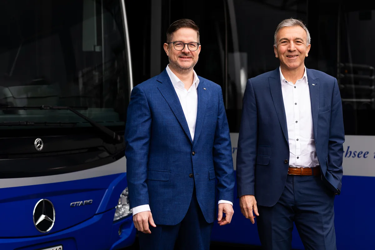 Joe Schmid (links) übernimmt per 1. November den Posten des VZO-Direktors Werner Trachsel. Zwei Herren in Anzügen stehen vor blauen Bussen.